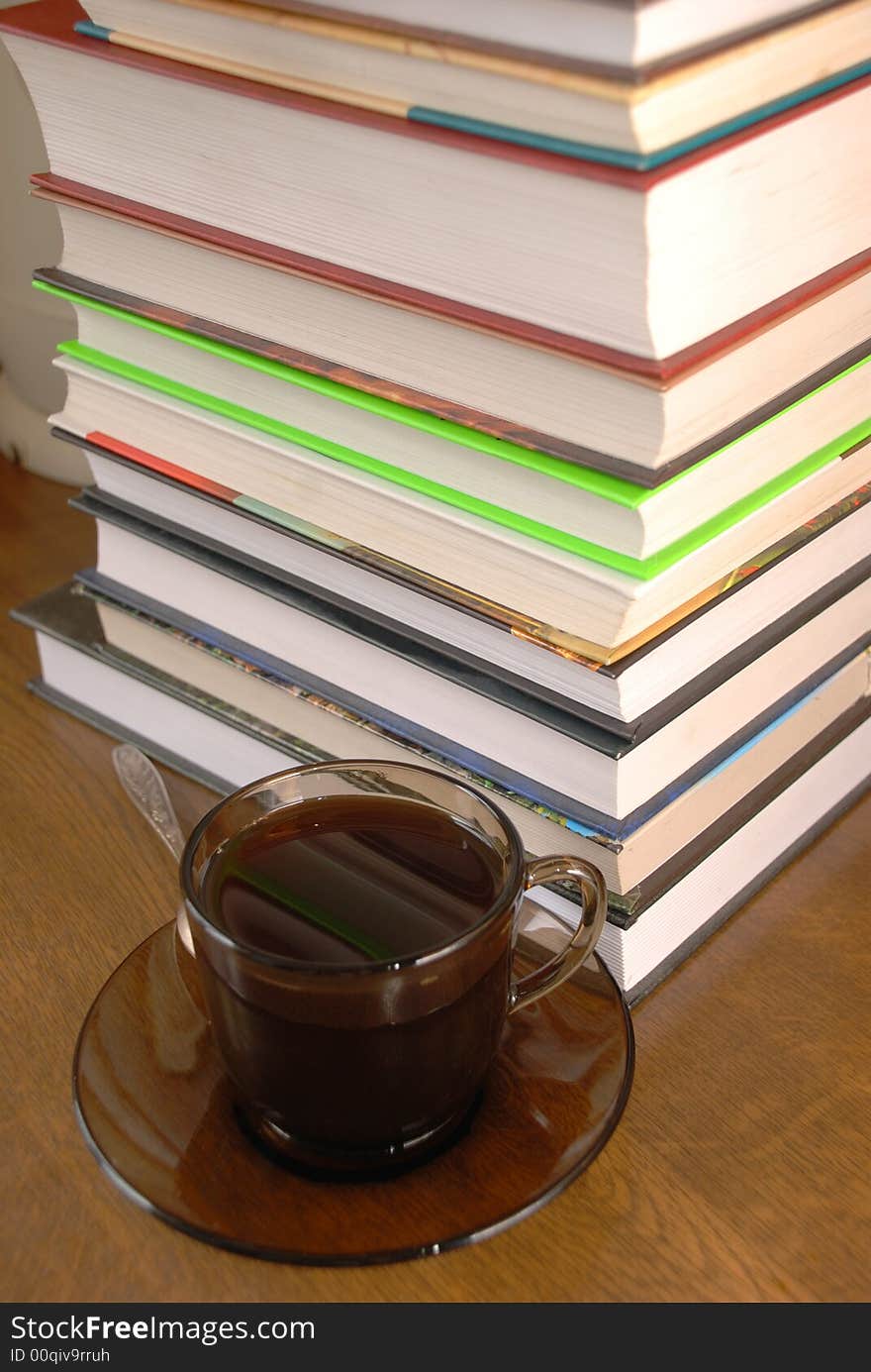 Cup of coffee and a pile of books