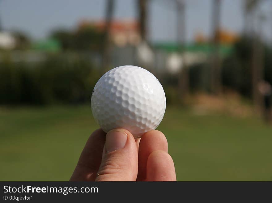 A golf ball in the hand of a golfer. A golf ball in the hand of a golfer