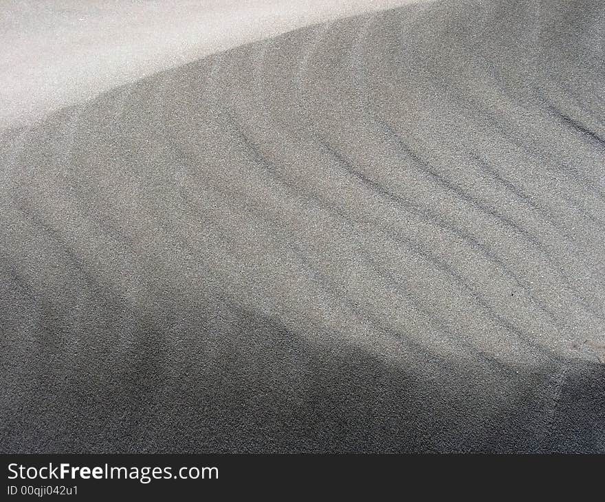 Close-up picture of fine sand with different tones and curves. Nice texture. Close-up picture of fine sand with different tones and curves. Nice texture.