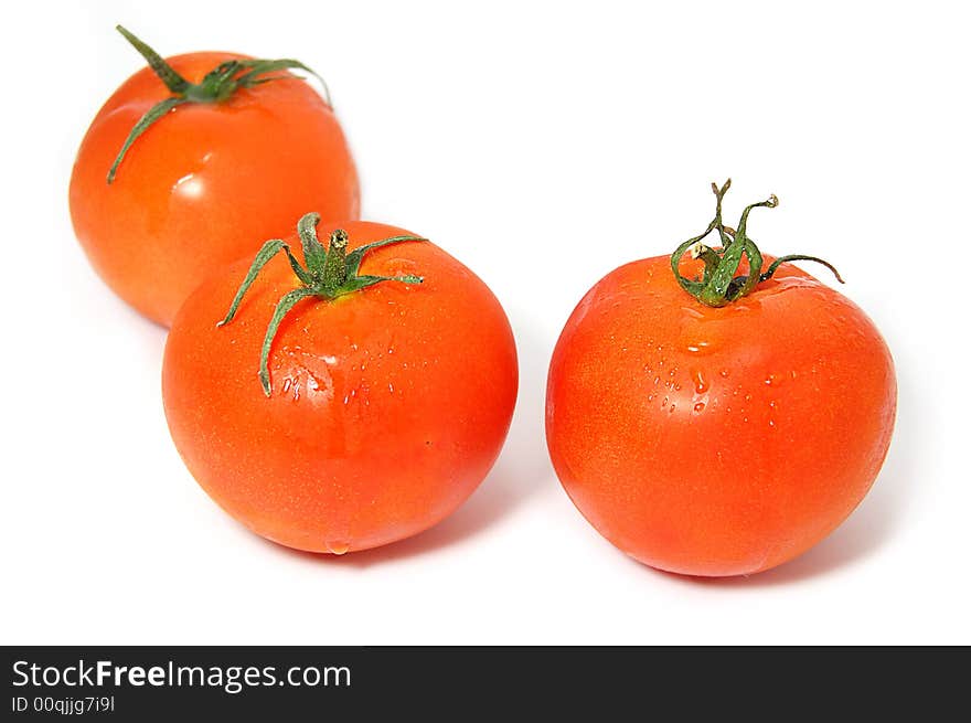 Three ripe red tomatos with green ends isolated on white. Three ripe red tomatos with green ends isolated on white