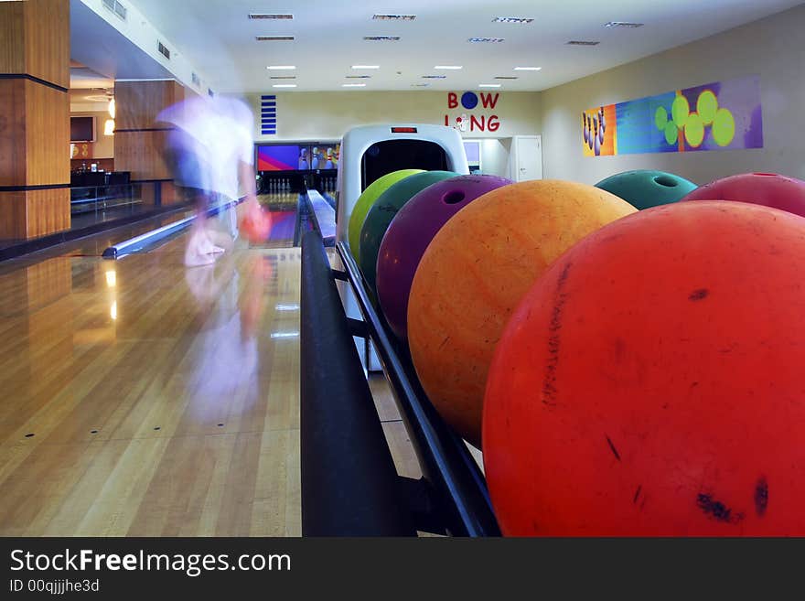 Close-up of the colored bowling balls and man