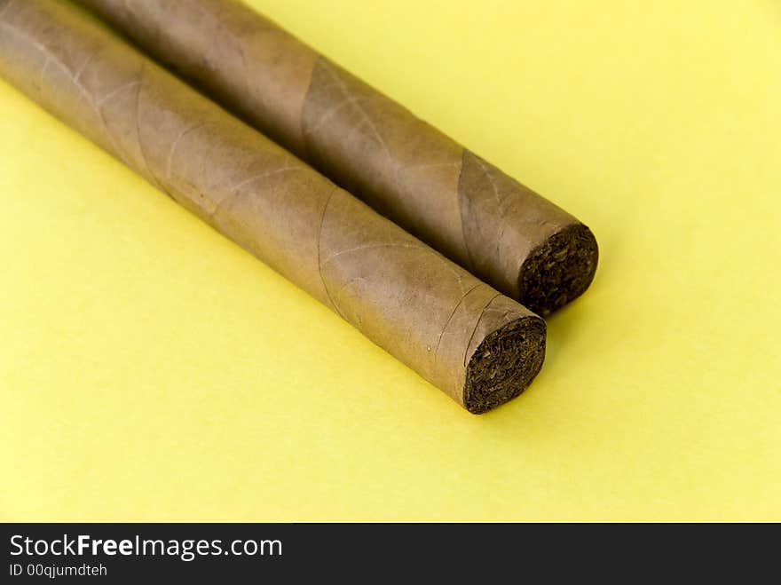 2 cigars on the yellow background