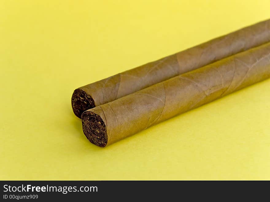 2 cigars on the yellow background