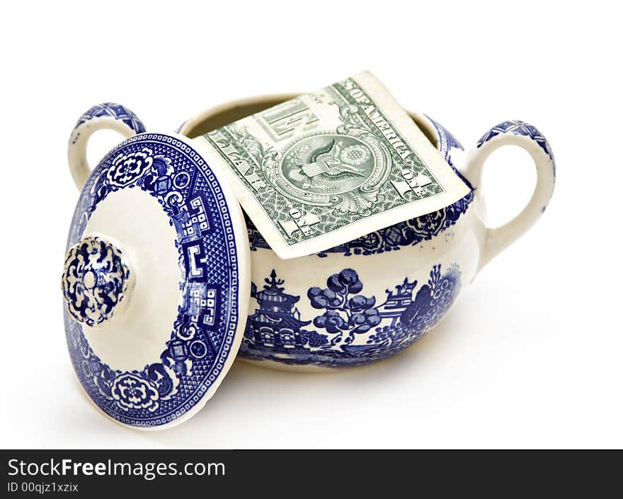 An American dollar in a sugar bowl.  Concept about economy and savings. An American dollar in a sugar bowl.  Concept about economy and savings.