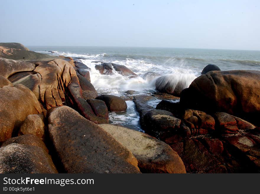 Round boulders by the sea ,rushed relentlessly by the sea waves