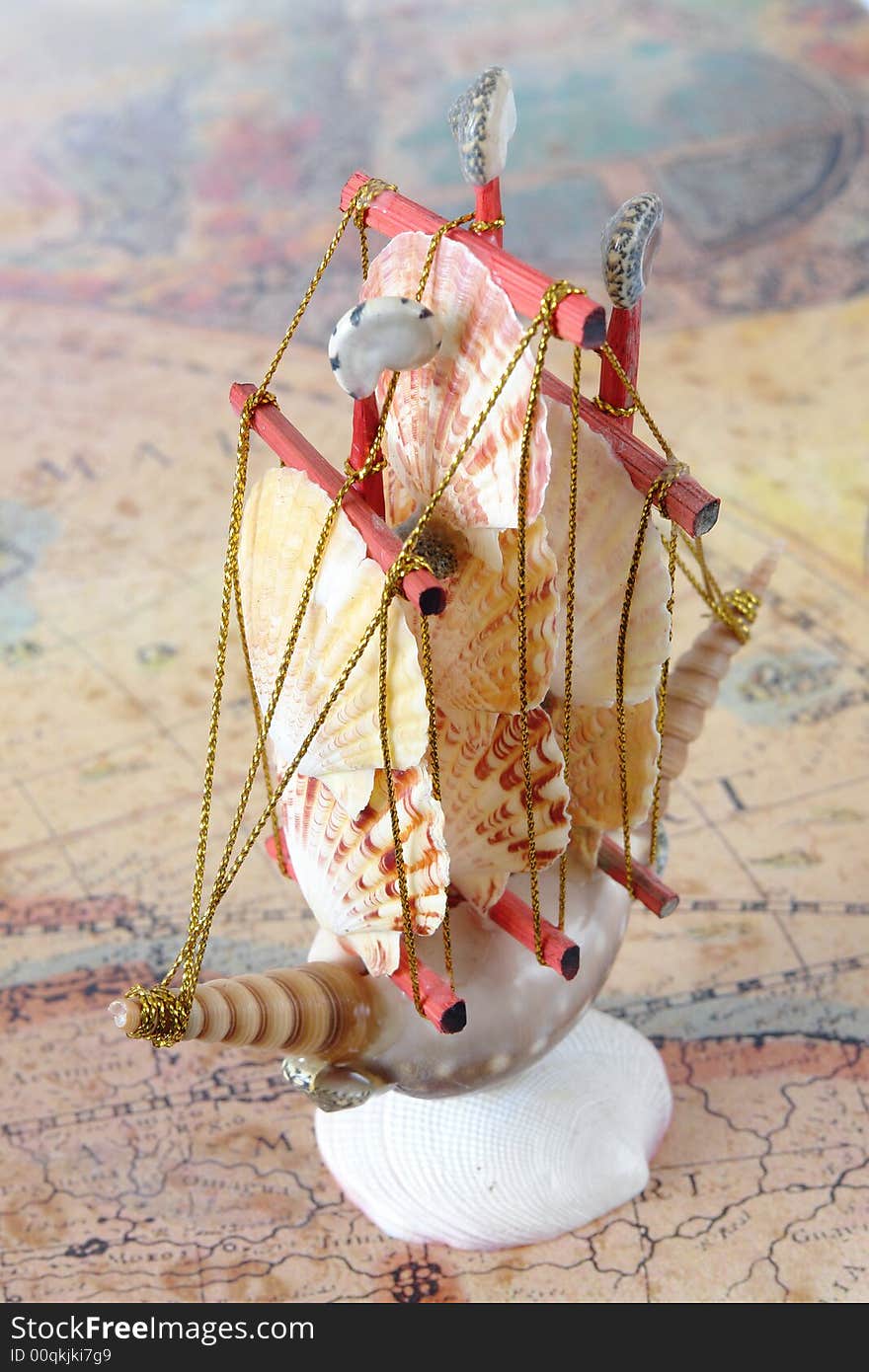 Sailing ship made from seashells over old map. Sailing ship made from seashells over old map