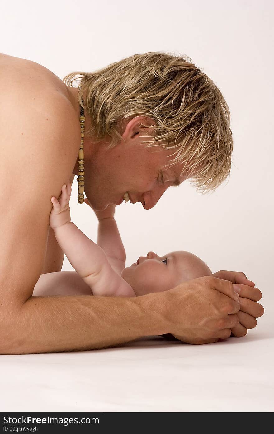 A baby that is reaching out to his father. A baby that is reaching out to his father