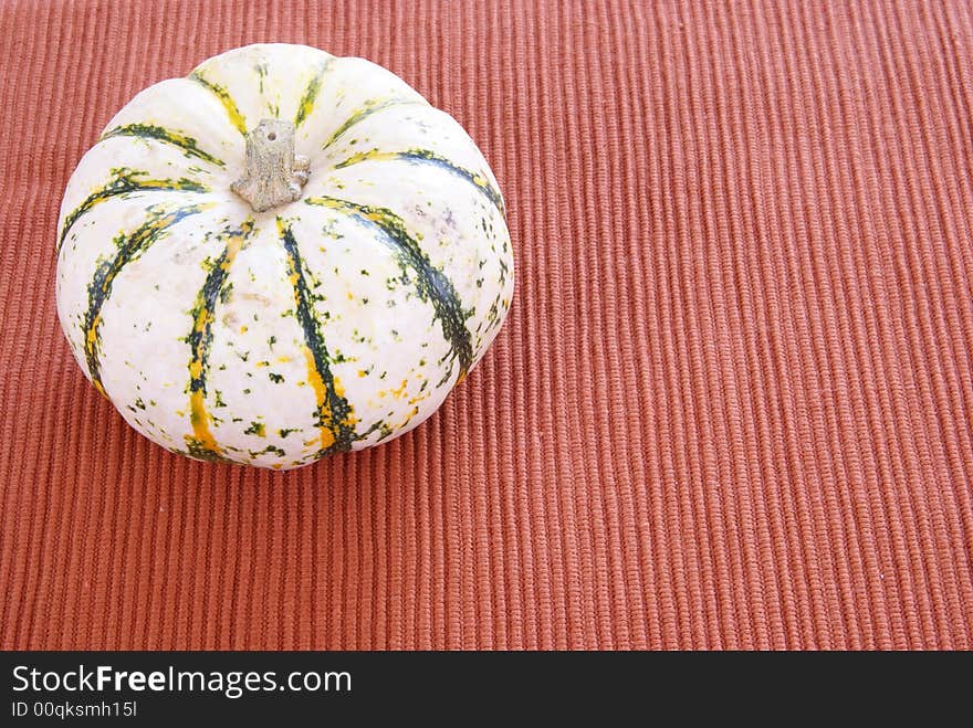 White striped pumpkin on cloth background. White striped pumpkin on cloth background.