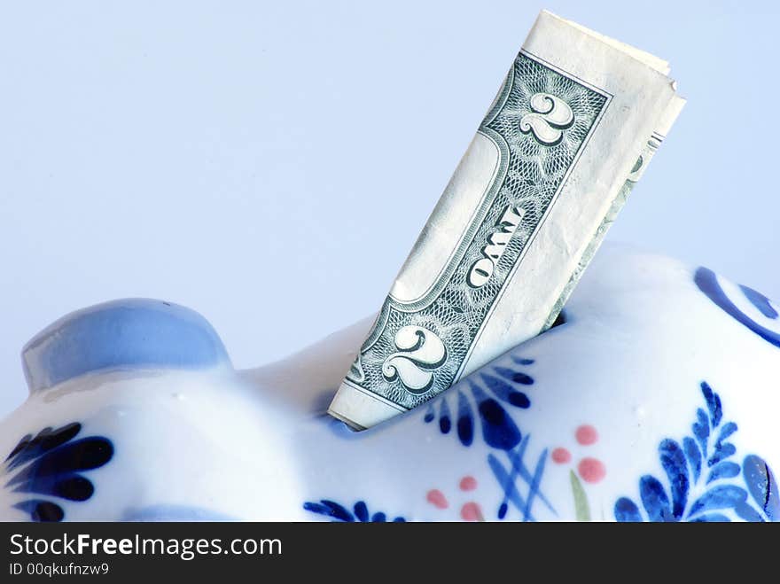 American Money two dollar bill standing in piggy bank slot closeup.