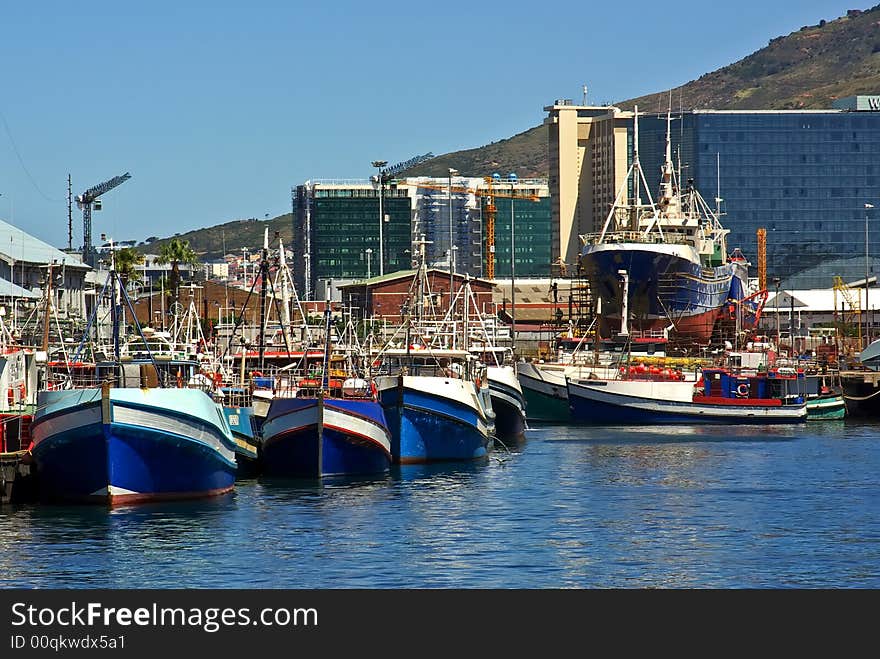 Fishing seine vessel during reparing in dock of city ocean bay of Cape Town South Africa near mountains. Fishing seine vessel during reparing in dock of city ocean bay of Cape Town South Africa near mountains