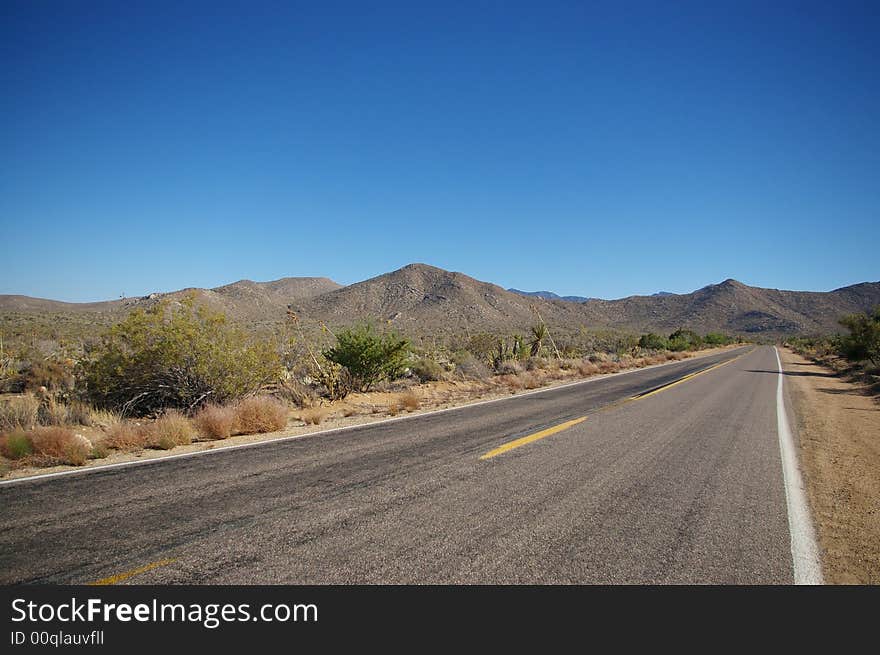 An empty road in the middle of the California desert.