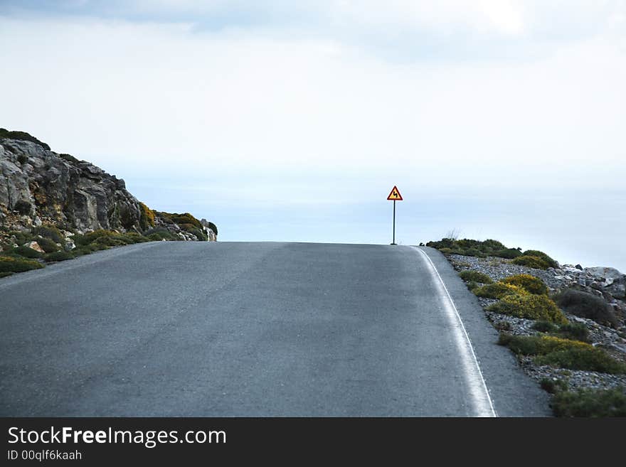 Road sign of dangerous curve at crete greece