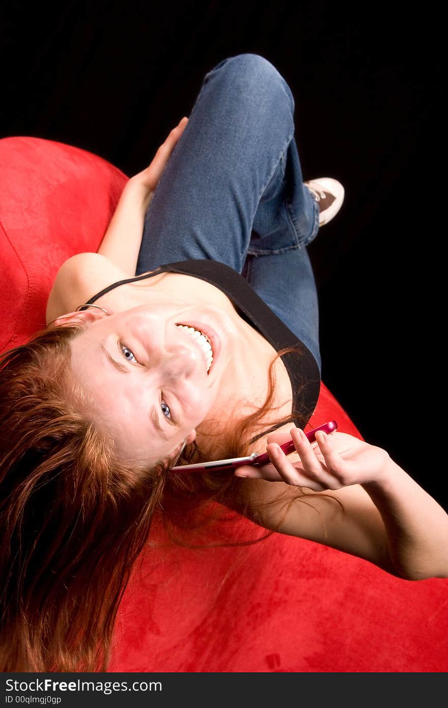 Redhead woman talking on cell phone upside down on couch. Redhead woman talking on cell phone upside down on couch.