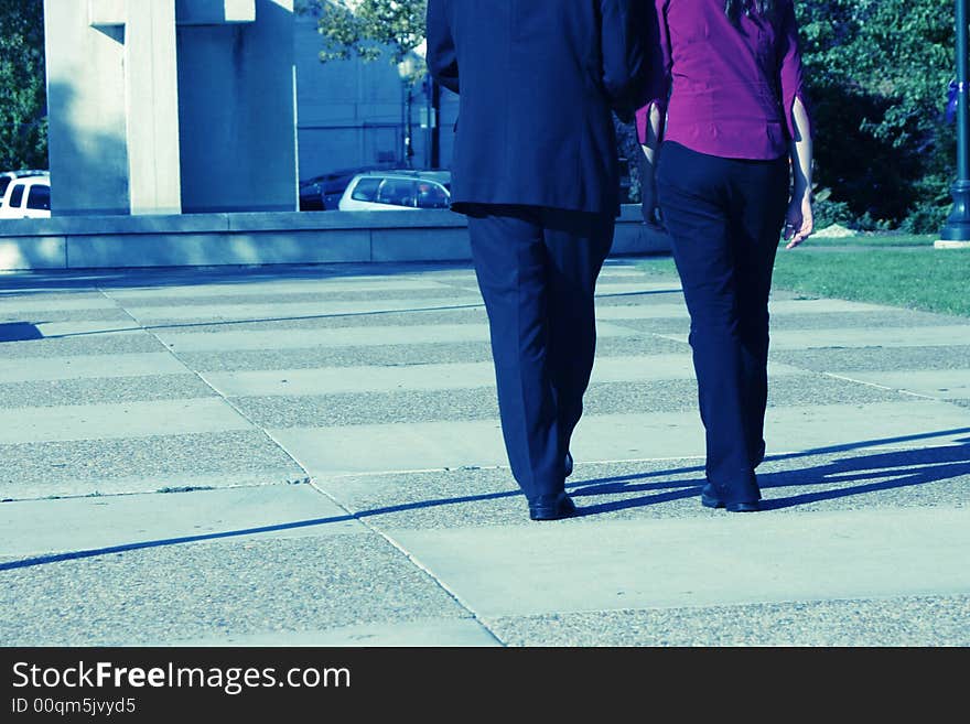 Rear view of businessman and businesswoman walking together towards building. Rear view of businessman and businesswoman walking together towards building