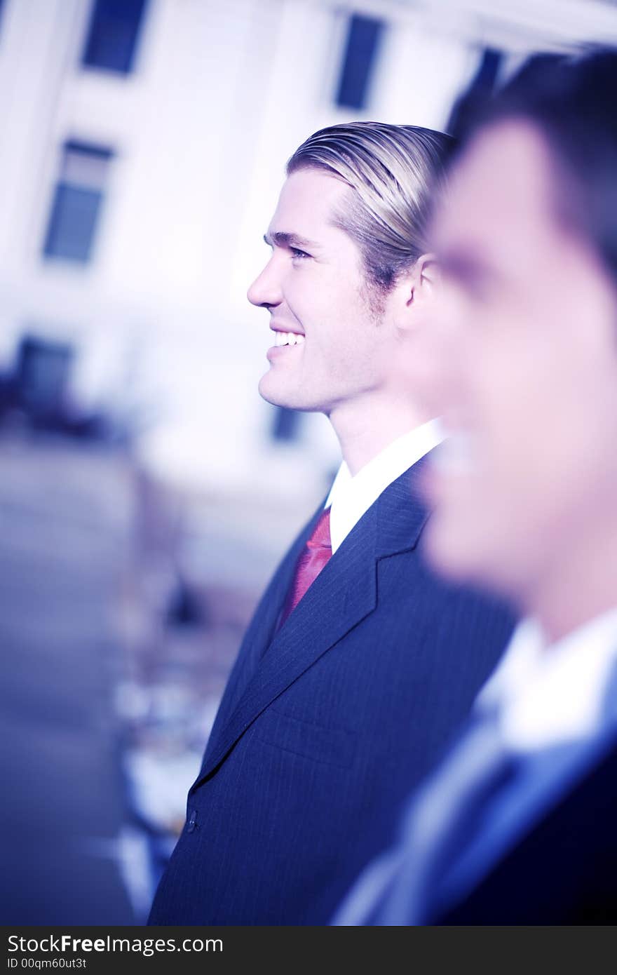 Two businessmen standing side to side in profile view