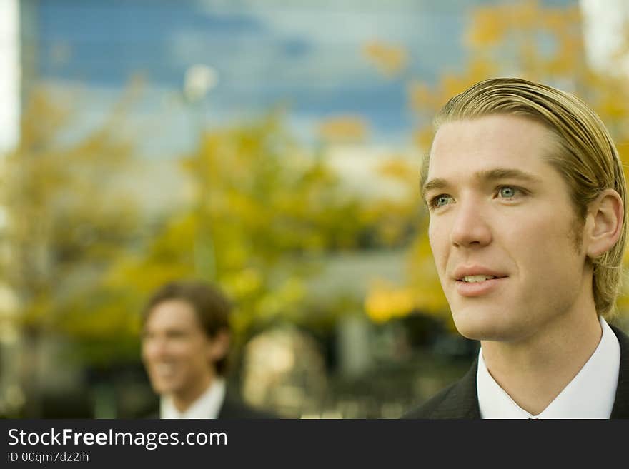 Head and shoulder view of two businessmen standing looking in same direction. Head and shoulder view of two businessmen standing looking in same direction