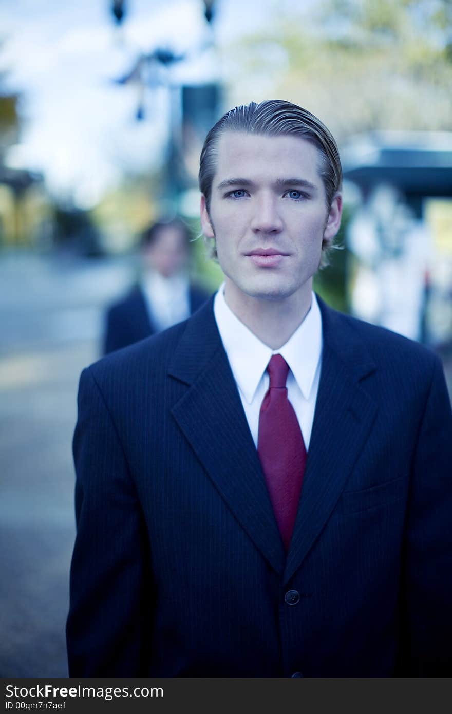 Two businessmen staggered one behind the other in full suits. Two businessmen staggered one behind the other in full suits