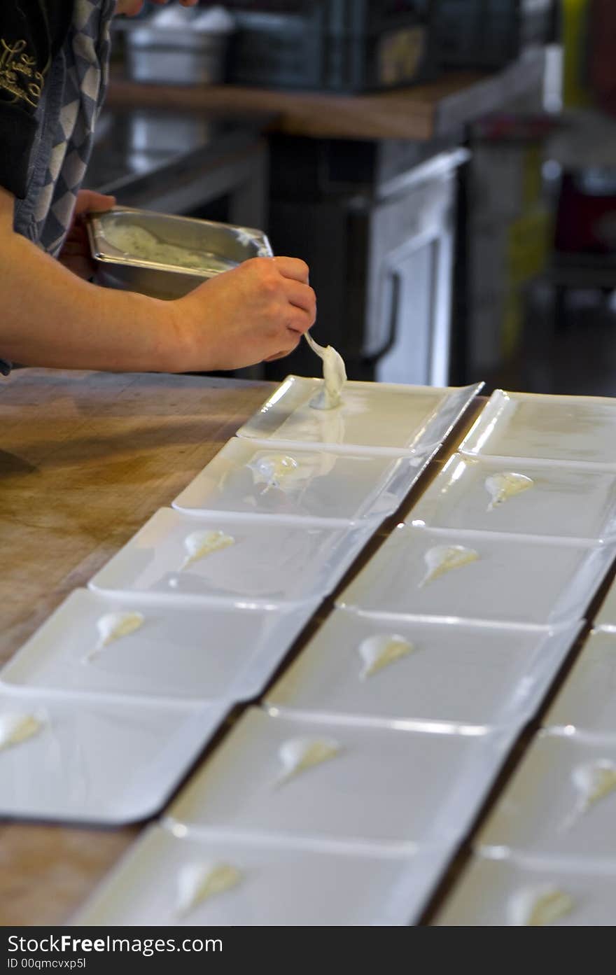 Someone dressing plates in a kitchen. Someone dressing plates in a kitchen