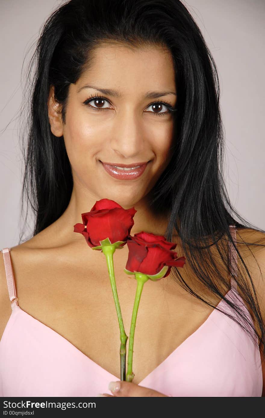 Pretty Indian girl holding two red roses. Pretty Indian girl holding two red roses.