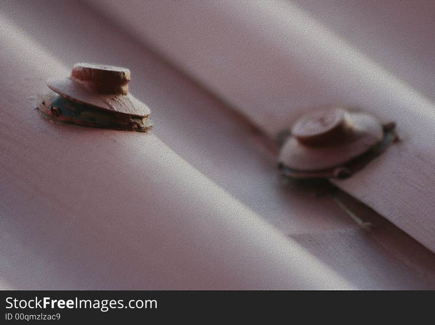 A macro shot of two bolts on a steel roof and afterwards edited in photoshop