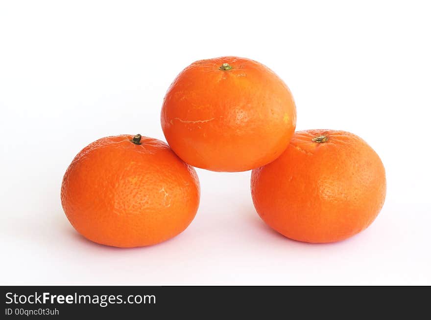 Pile of three orange tangerines isolated on white, horizontal.