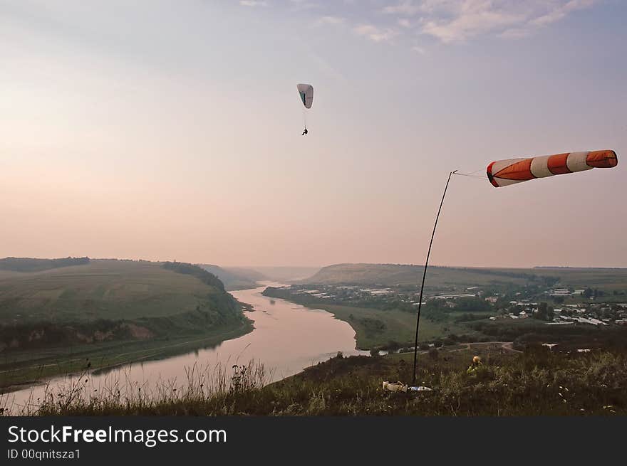 Man Flying on Paraglider in evening above the Dnestr river canyon, Ukraine