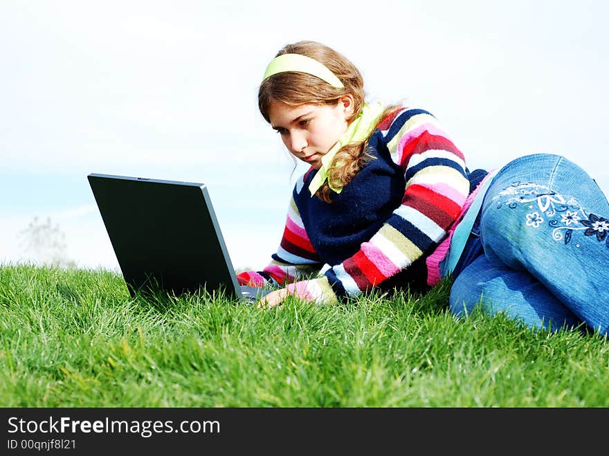 Young girl is working on laptop at outdoor location. Young girl is working on laptop at outdoor location