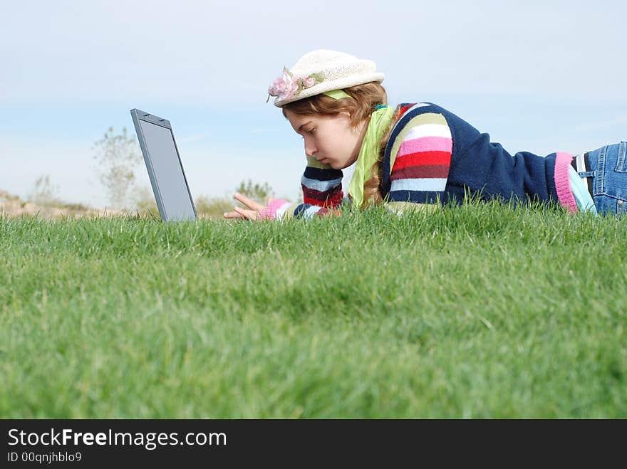 Young girl is working on laptop at outdoor location. Young girl is working on laptop at outdoor location