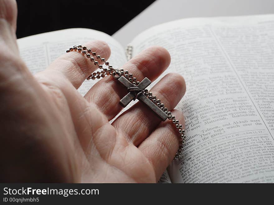 Holy bible open with a cross on a hand. Holy bible open with a cross on a hand