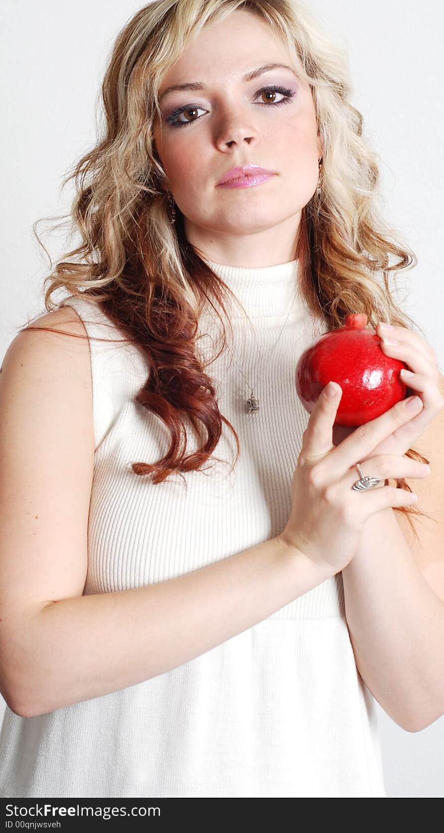 Beautiful woman is holding a fruit in her hands. Beautiful woman is holding a fruit in her hands