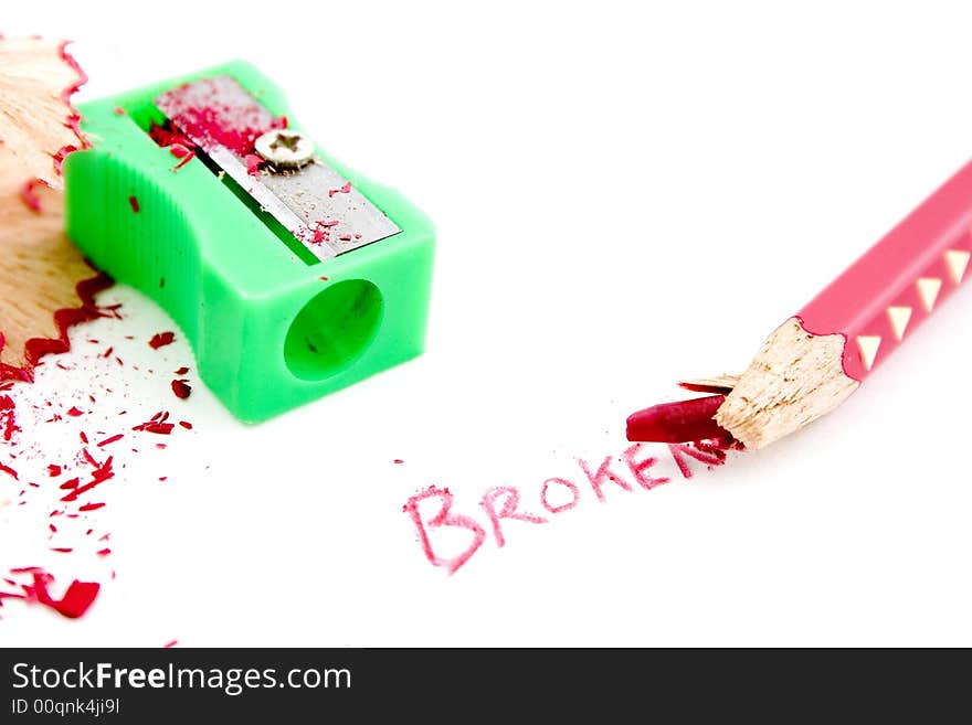 Broken wooden red pencil tip with green sharpener and written word. Broken wooden red pencil tip with green sharpener and written word