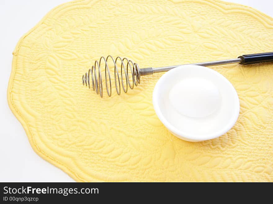 Whole white egg in bowl on yellow placemat. Whole white egg in bowl on yellow placemat