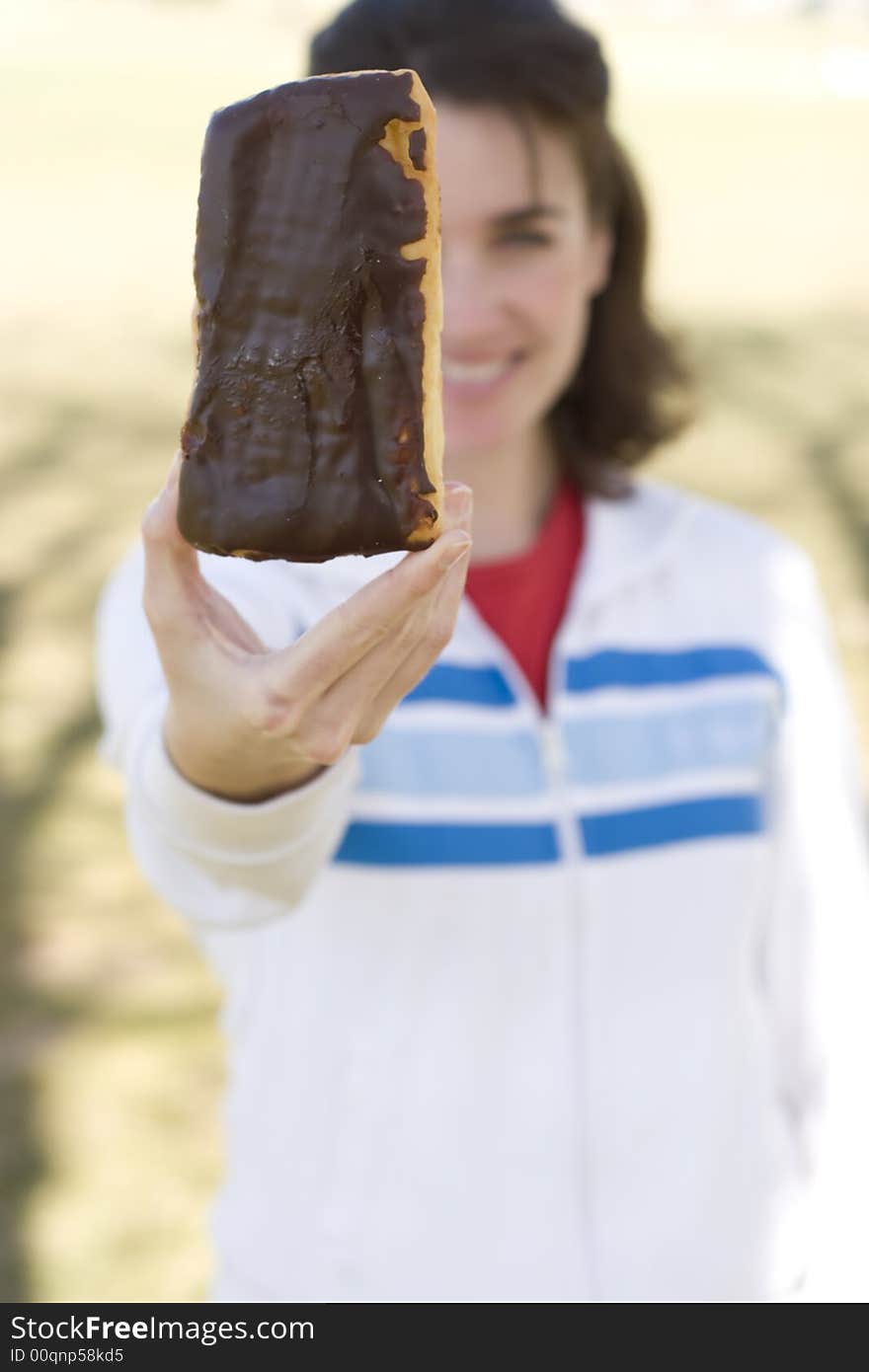 Woman standing holding donut in front of her face. Woman standing holding donut in front of her face