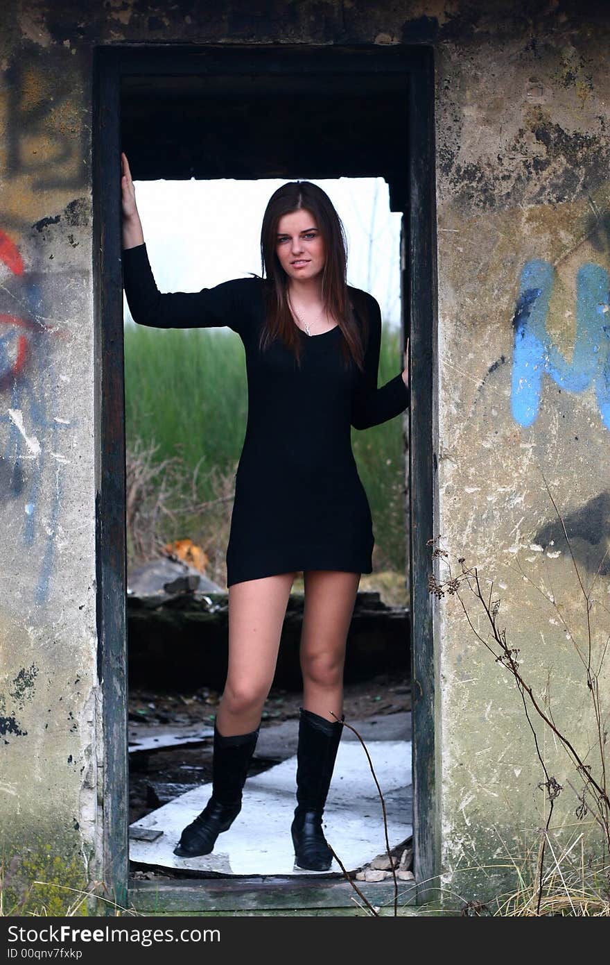 Young girl in the field on the warm winter day in the old ruin