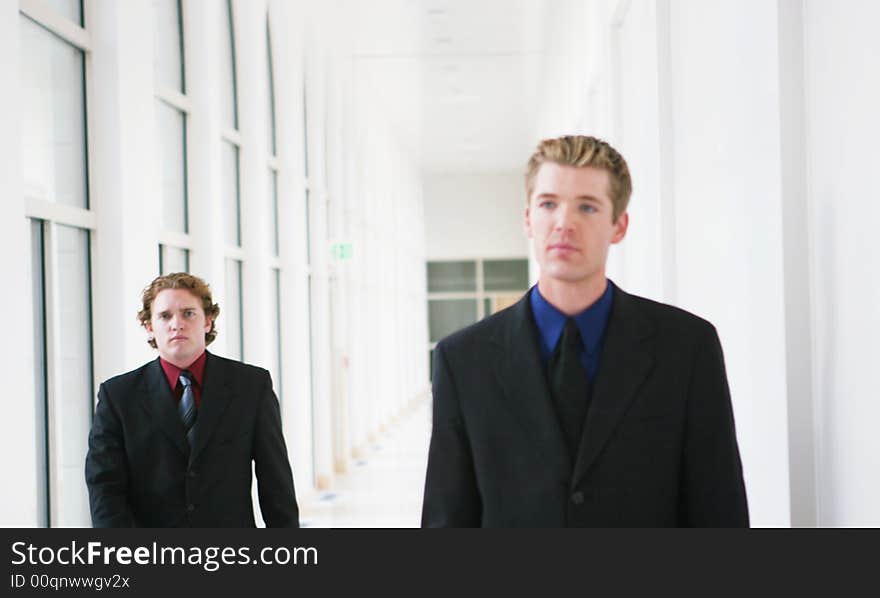 Two businessmen walking in hallway