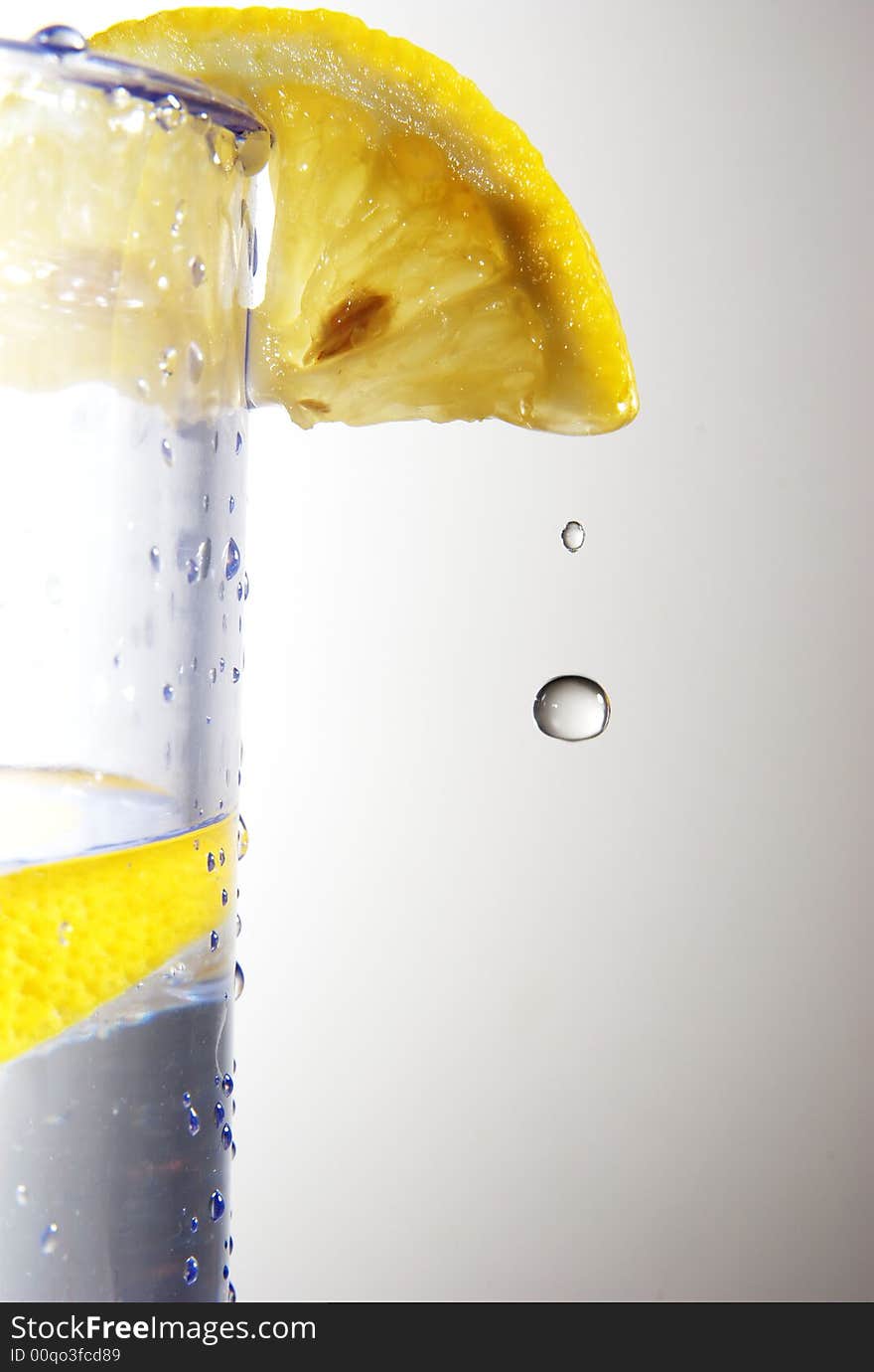 A droplet of water falls from a lemon slice. A droplet of water falls from a lemon slice.