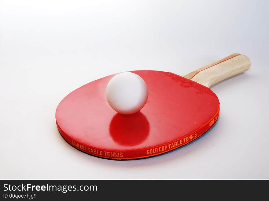 Red ping-pong paddle with the ball isolated on white