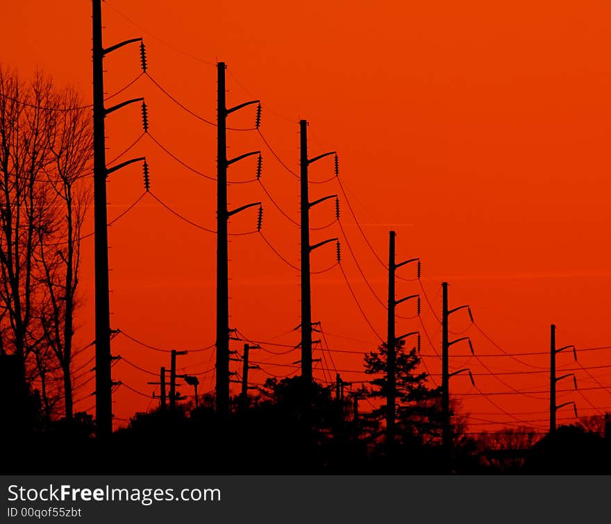 Power transmission lines silhouetted against a bright orange background. Power transmission lines silhouetted against a bright orange background