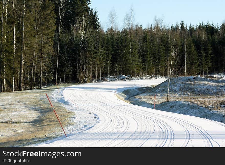 Snowy road with wheel tracks and a curve