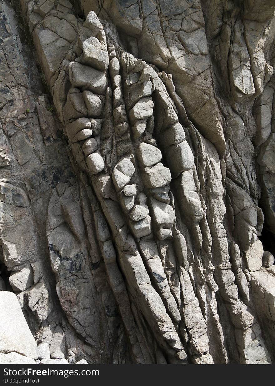 A close-up of the texture of grey rough surface of rock on seacoast. Russian Far East, Japanese sea, Primorye. A close-up of the texture of grey rough surface of rock on seacoast. Russian Far East, Japanese sea, Primorye.