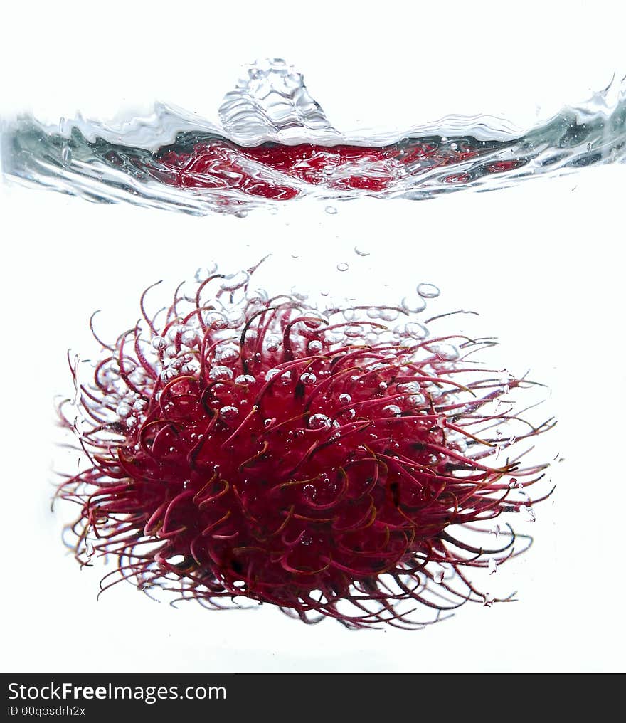 Rambutan fruit dropped into water. Rambutan fruit dropped into water