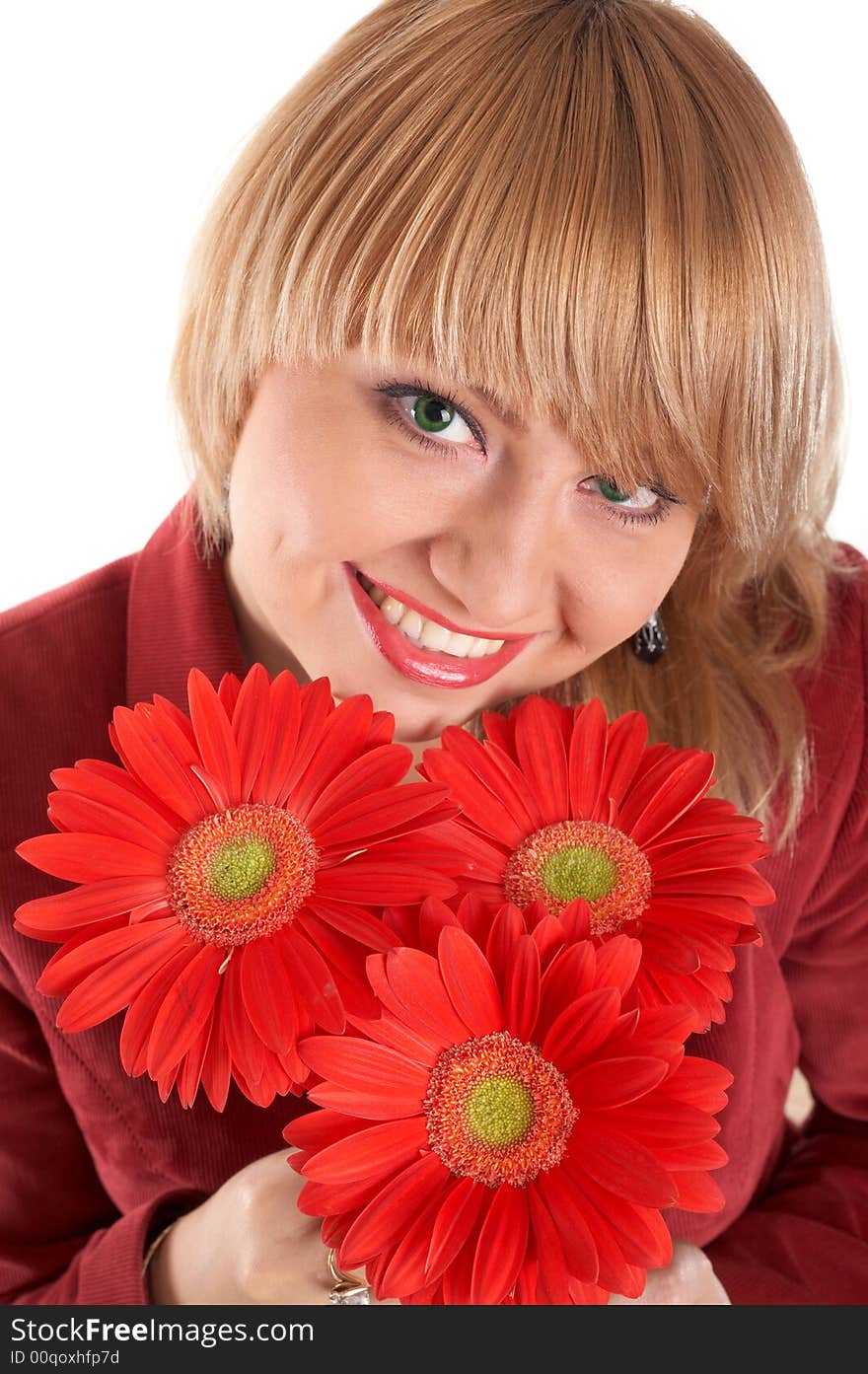 A smiling green-eyed girl with red flowers