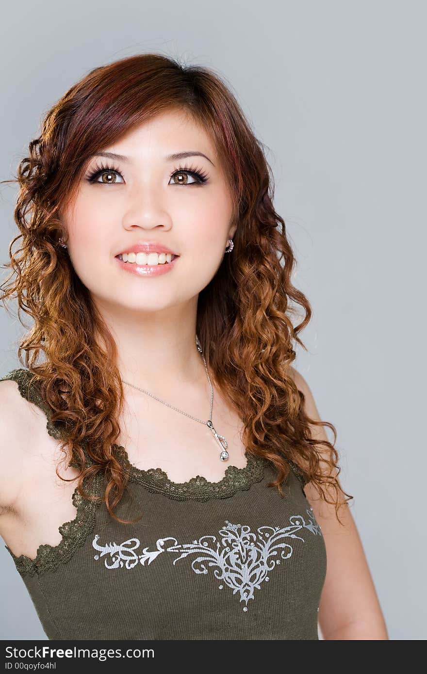 Sweet smiling young woman with attractive eyes and long curly hair looking up. Sweet smiling young woman with attractive eyes and long curly hair looking up