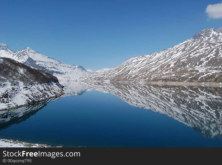 Lake between mountains in a beautiful day, with a sky without clouds and an warm sun