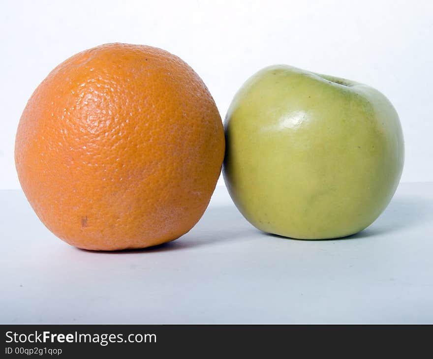 Orange and apple against a plain background. Orange and apple against a plain background