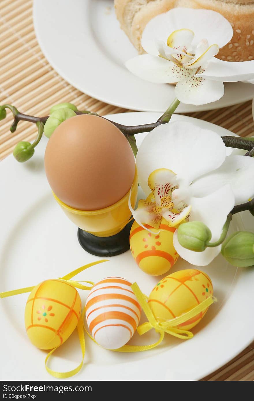 Nature egg with easter colored eggs and orchid on a table. Nature egg with easter colored eggs and orchid on a table.