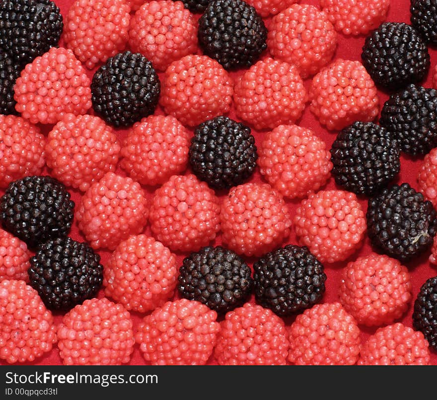 Sweets in the form of berries of a raspberry on a red background