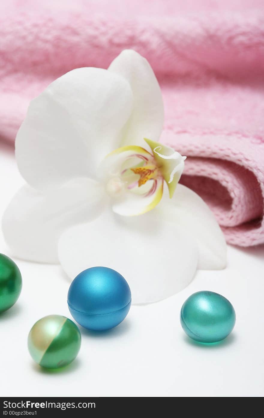 Orchid and bath oil pearls with pink towel. Orchid and bath oil pearls with pink towel.