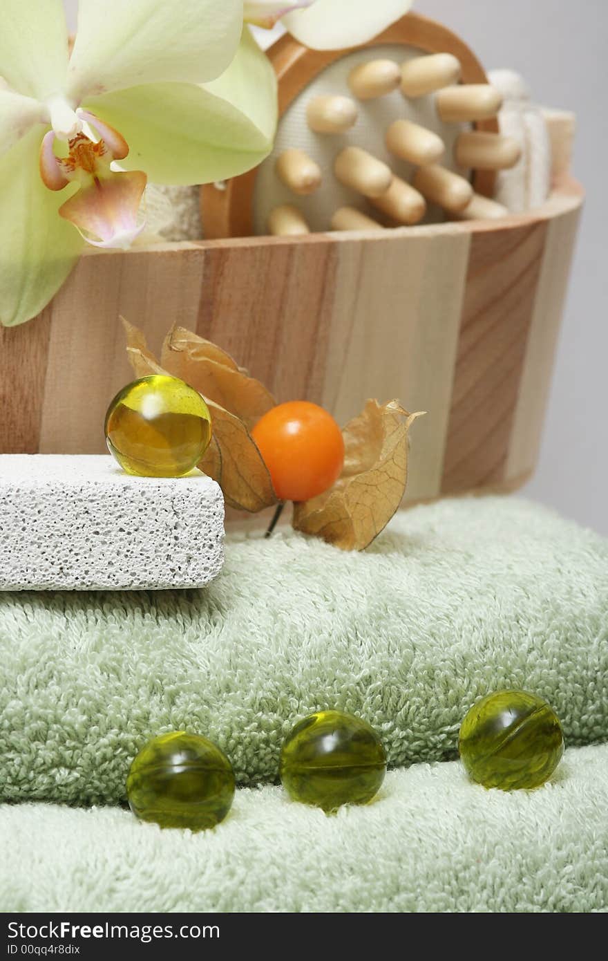 Accessories for a being relaxing wellness treatment with orchid on green towel. Accessories for a being relaxing wellness treatment with orchid on green towel.