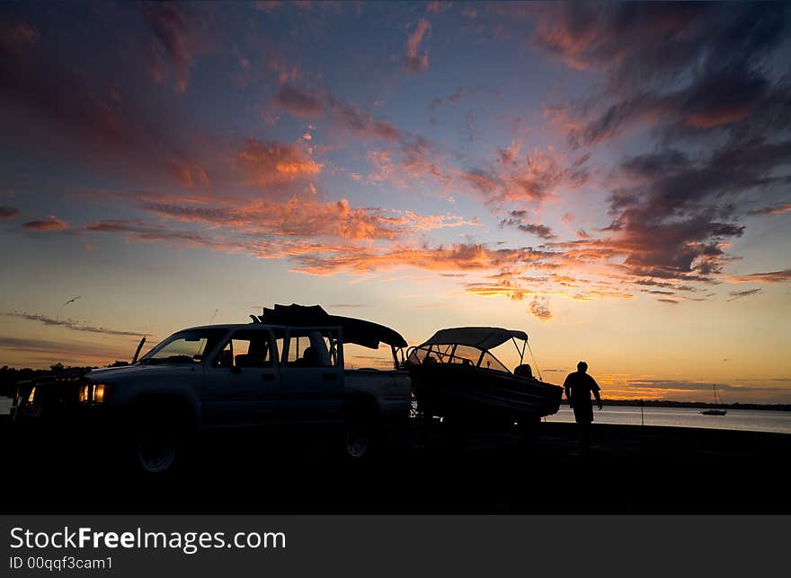 A fisherman prepares to launch his vessel at the dawn of a new day. A fisherman prepares to launch his vessel at the dawn of a new day